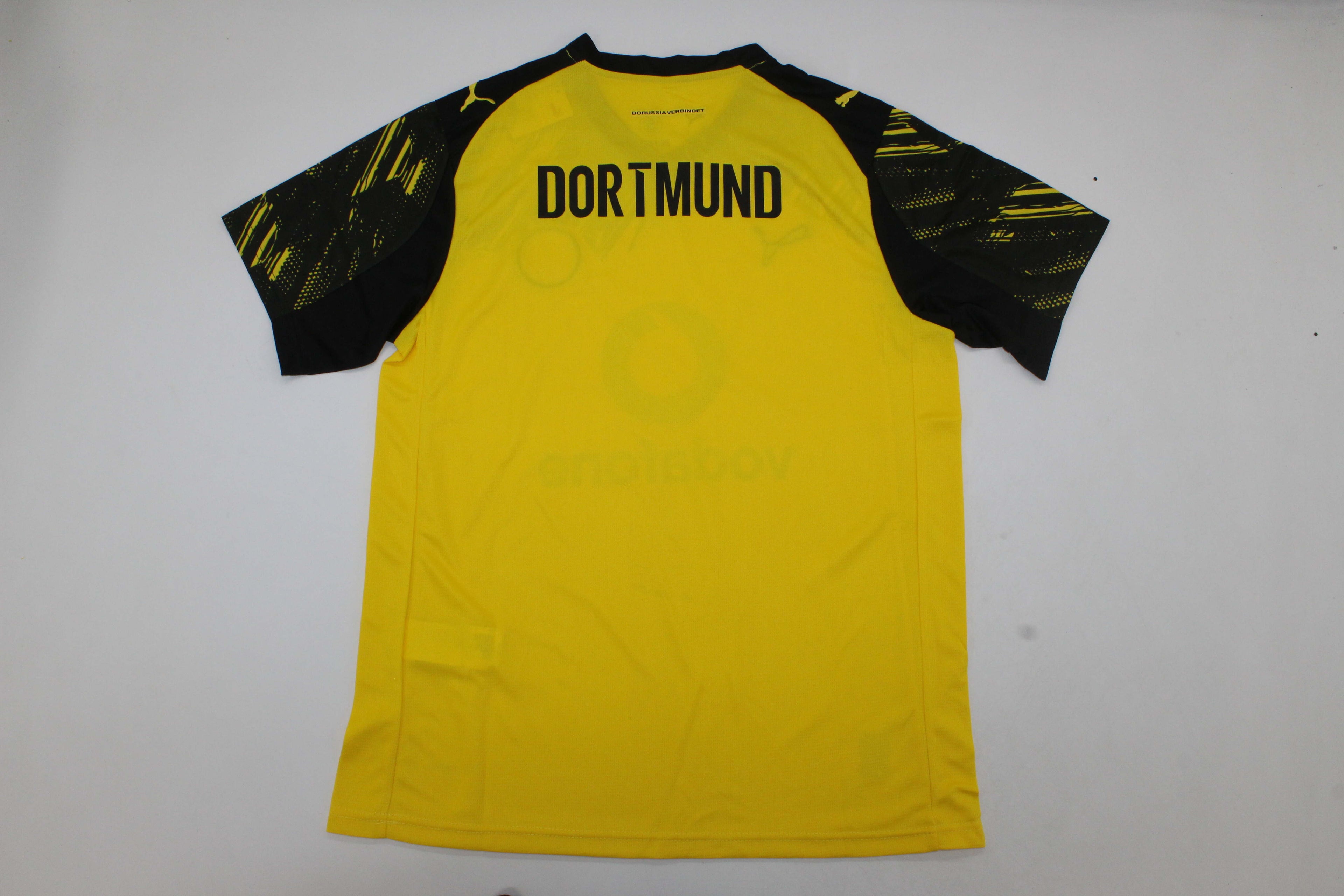 Borussia Dortmund official home jersey folded neatly with black and yellow accents.